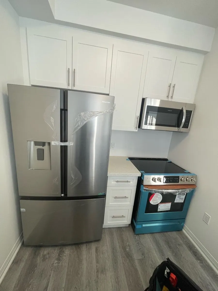 Refrigerator, range and over-the-range microwave installed in a kitchen